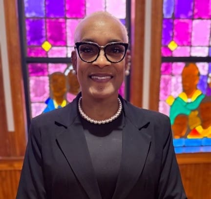 Smiling person in glasses and pearl necklace