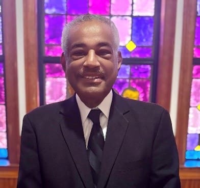Smiling man in suit by stained glass