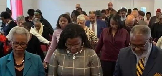 Congregation bowing heads in prayer at church
