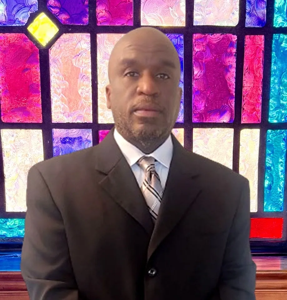 Man in suit in front of stained glass